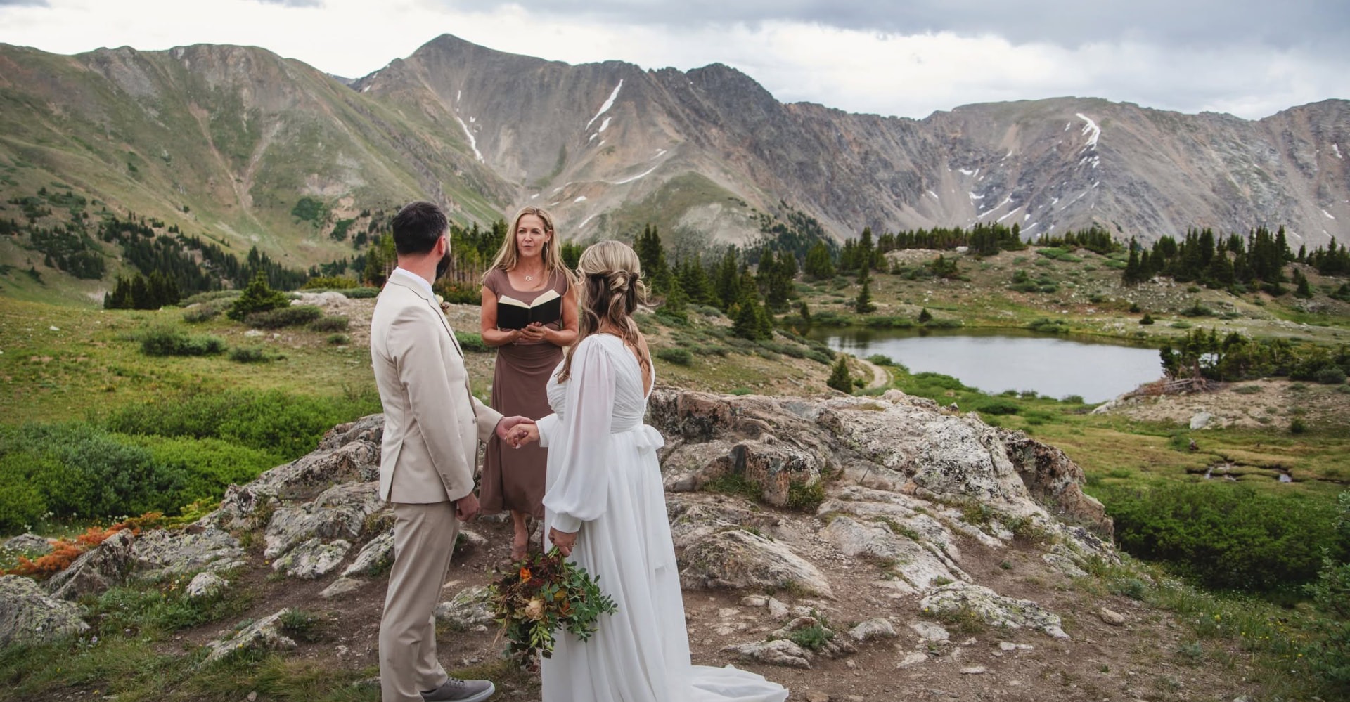 A couple sharing their Colorado mountain wedding ceremony with their officiant